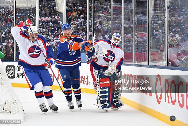 Dave Babych and Bob Essensa of the Winnipeg Jets alumni battle for the puck with Craig Simpson of the Edmonton Oilers alumni during the 2016 Tim...