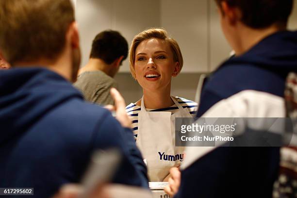 Actress Scarlett Johansson speaks to a customer at the opening of the Yummy Pop gourmet popcorn shop in the Marais district of Paris on October 22,...