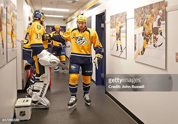Frederick Gaudreau taps goalie Marek Mazanec of the Nashville Predators as he walks out for his first NHL game on October 22, 2016 at Bridgestone...