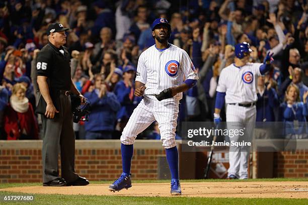 Dexter Fowler of the Chicago Cubs reacts after scoring a run on an RBI single hit by Kris Bryant in the first inning against the Los Angeles Dodgers...