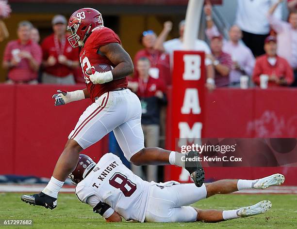 Jonathan Allen of the Alabama Crimson Tide returns a fumble for a touchdown as he steps over Trevor Knight of the Texas A&M Aggies at Bryant-Denny...