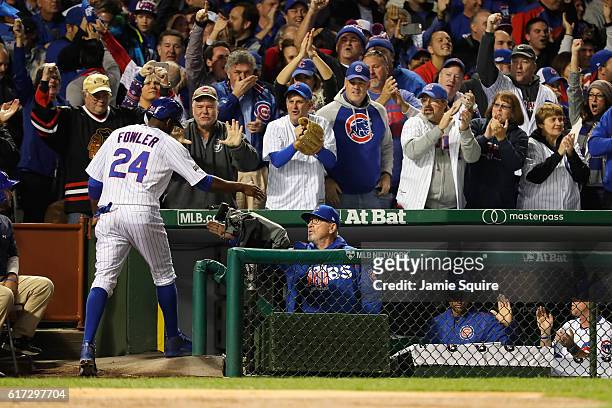 Dexter Fowler of the Chicago Cubs celebrates with manager Joe Maddon at the dugout after scoring a run on an RBI single hit by Kris Bryant in the...
