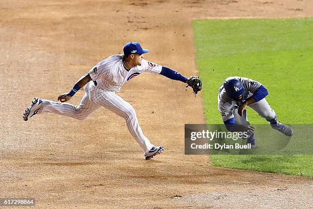 Javier Baez of the Chicago Cubs tags out Andrew Toles of the Los Angeles Dodgers at second base in the first inning during game six of the National...