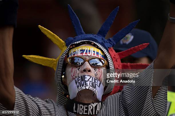 Woman, dressed as the Statue of Liberty and gagged with slogan, is seen as a group of women, led by Lilian Tintori, wife of imprisoned opposition...