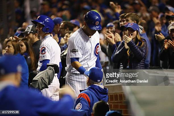 Willson Contreras of the Chicago Cubs celebrates with manager Joe Maddon at the dugout after hitting a solo home run in the fourth inning against the...