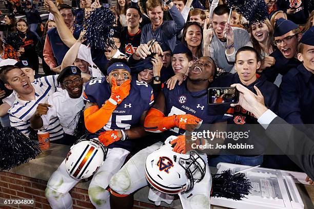 Joshua Holsey and Deshaun Davis of the Auburn Tigers celebrate with fans after the game against the Arkansas Razorbacks at Jordan-Hare Stadium on...