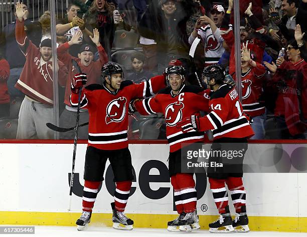 Taylor Hall of the New Jersey Devils celebrates his game winning goal with teammates Andy Greene and Adam Henrique in overtime against Minnesota Wild...