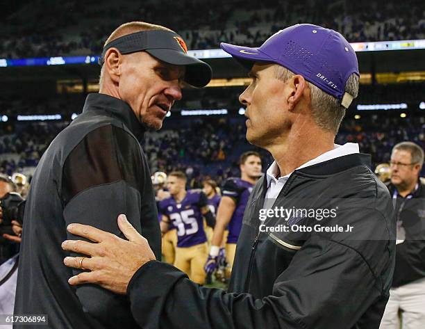 Head coach Chris Petersen of the Washington Huskies is congratulated by head coach Gary Andersen of the Oregon State Beavers after the Huskies beat...