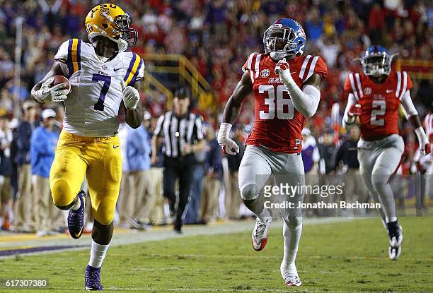 Leonard Fournette of the LSU Tigers runs past Zedrick Woods of the Mississippi Rebels for a 76-yard touchdown during the first half of a game at...