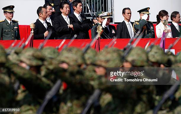Japanese Prime Minister Shinzo Abe, fourth from left, reviews troops of the Self Defense Forces marching during the annual review at the Japan Ground...
