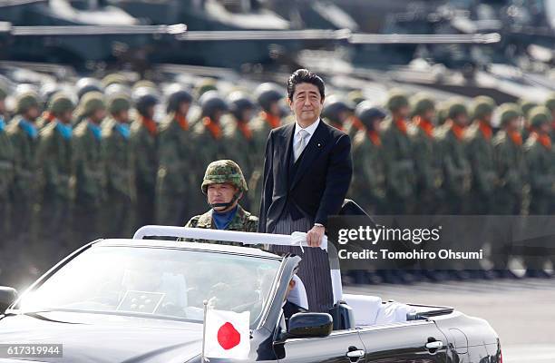 Japanese Prime Minister Shinzo Abe, center right, inspects troops of the Self Defense Forces during the annual review at the Japan Ground...