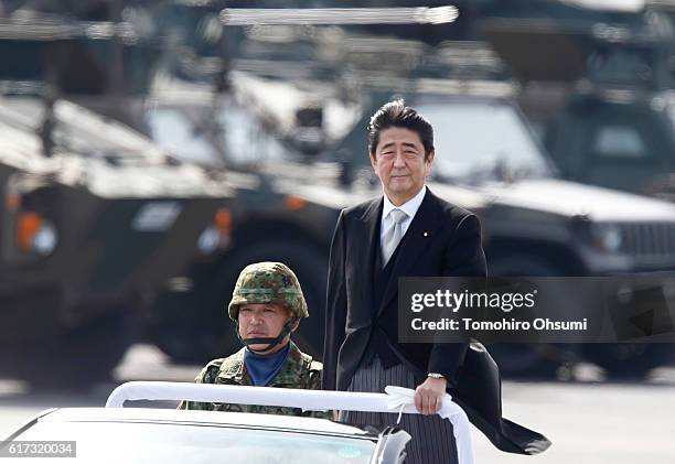 Japanese Prime Minister Shinzo Abe, center right, inspects troops of the Self Defense Forces during the annual review at the Japan Ground...
