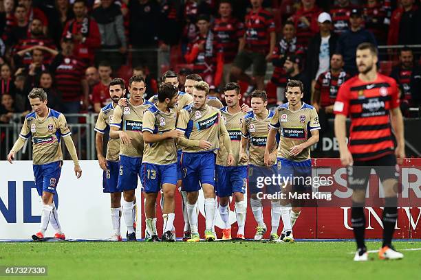 Andrew Hoole of the Jets celebrates with team mates after scoring the final goal during the round three A-League match between the Western Sydney...