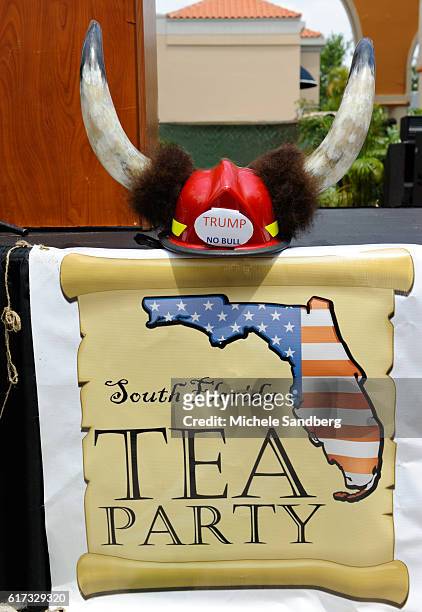 Close up of South Florida Tea Party banner at the group's Tax Day event, Boca Raton, Florida, April 16, 2011. Above it is a hard hat decorated with...