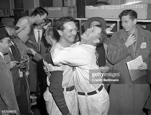 Cub manager Charlie Grimm gives Stan Hack a great big bear hug in dressing room after 6th World Series game. Stan's double in the 12th inning scored...
