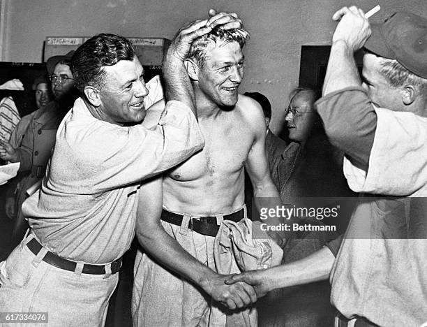 Manager Charlie Grimm, of the Chicago Cubs looks mighty happy as he massages Hank Borowy's hair in the Cub clubhouse after the Cubs won the National...