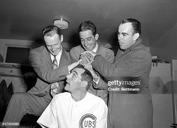 Captain Phil Cavarretta, of National Champion Chicago Cubs, gets his batting crown from pitcher Hank Borowy, first baseman Reggie Otera, and...