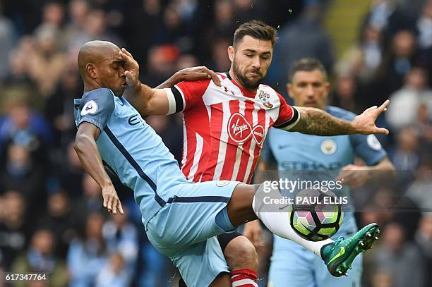 Manchester City's Brazilian midfielder Fernandinho vies with Southampton's English striker Charlie Austin during the English Premier League football...