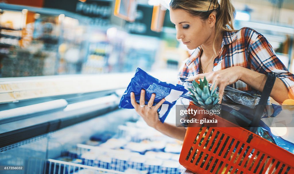 Woman bying some frozen food at a supermarket.