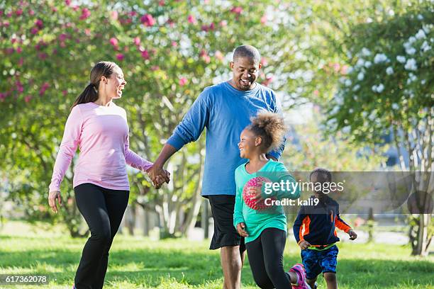 black parents walking in park, children running, playing - 4 people playing games stock pictures, royalty-free photos & images