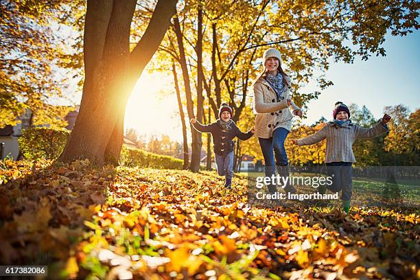 happy kids running in park on sunny autumn day. - happy people running stockfoto's en -beelden