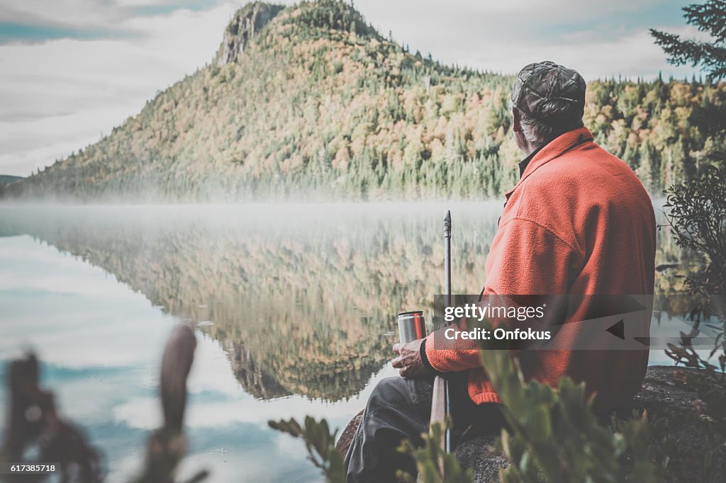 Senior Man Hunter Relaxing with Coffee in Nature