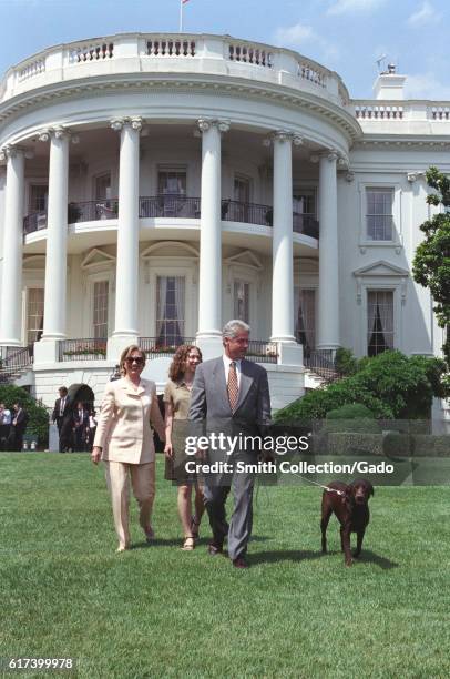 President William Jefferson Clinton, First Lady Hillary Rodham Clinton, and Chelsea Clinton walking pet Buddy the Dog on the South Lawn of the White...