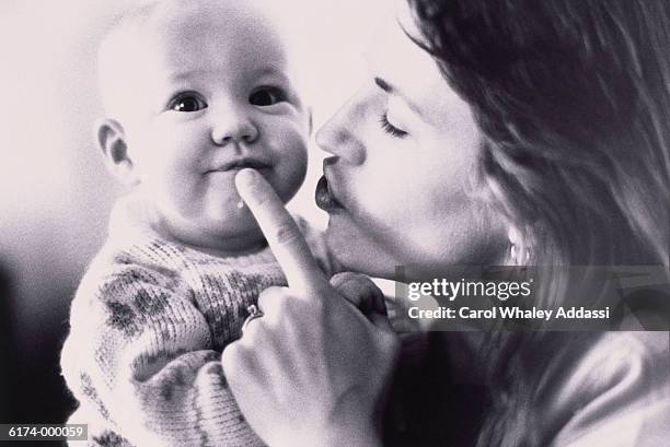 mother silencing baby - carol addassi stock pictures, royalty-free photos & images