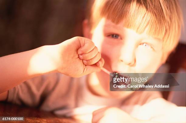 boy with lollipop - carol addassi stock-fotos und bilder