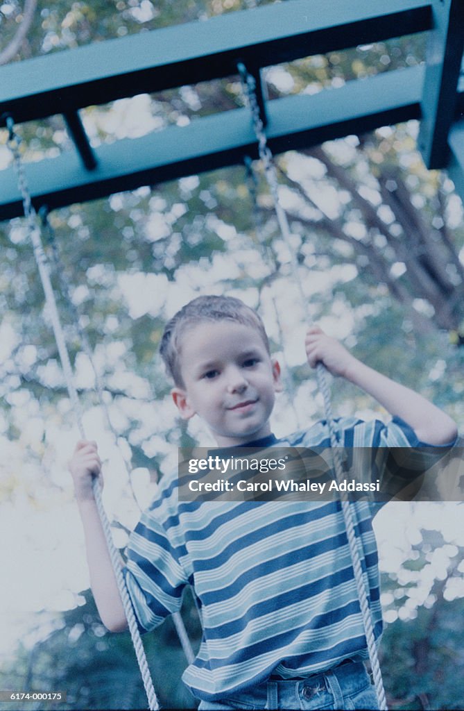 Boy Standing on Swing