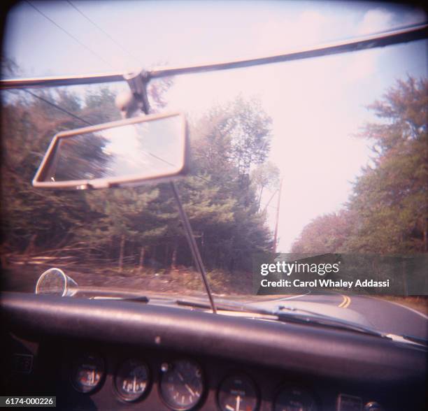 sports car on road in forest - carol addassi stock-fotos und bilder