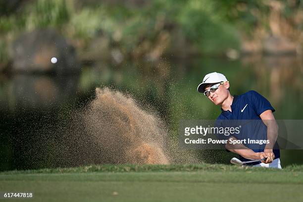 Li Haotong of China plays a bunker shot during the World Celebrity Pro-Am 2016 Mission Hills China Golf Tournament on 22 October 2016, in Haikou,...