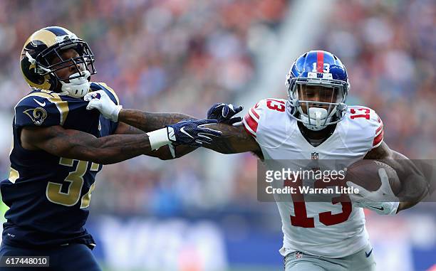 Odell Beckham Jr of the New York Giants hands off Troy Hill of the Los Angels Rams during the NFL International Series match between New York Giants...