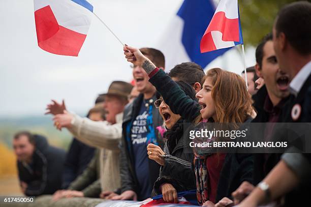 French far-right Front National 's supporters shout against pro-refugee demonstrators in La Tour d'Aigues on October 23, 2016. A hundred of FN...