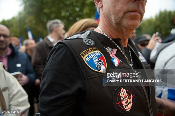 French far-right Front National 's supporter wears a shield reading "Bikers for Marine 2017", as he attends a rally against migrants' hosting in La...