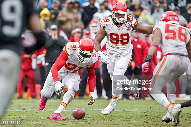 Linebacker Tamba Hali of the Kansas City Chiefs picks up a loose ball knocked out of the hands of quarterback Derek Carr of the Oakland Raiders in...