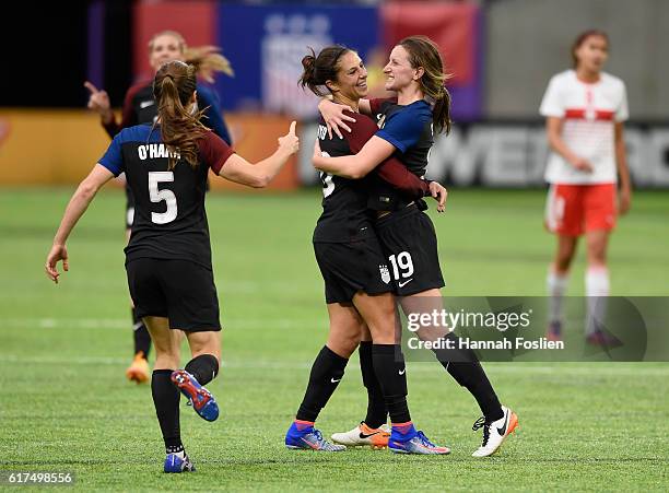 Kelley O'Hara, Carli Lloyd and Andi Sullivan of United States celebrate a goal by Lloyd against Switzerland during the first half of the friendly...