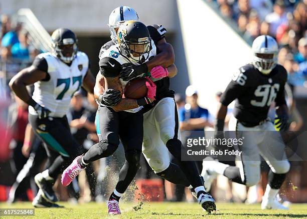 Rashad Greene of the Jacksonville Jaguars is tackled by Malcolm Smith of the Oakland Raiders during the second half of the game at EverBank Field on...