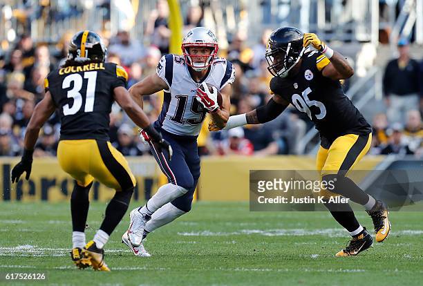 Chris Hogan of the New England Patriots runs between Ross Cockrell and Jarvis Jones of the Pittsburgh Steelers after making a catch in the first...