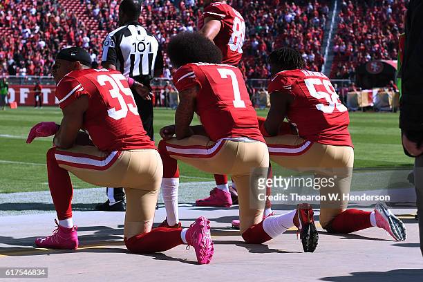 Eric Reid, Colin Kaepernick and Eli Harold of the San Francisco 49ers kneel in protest during the national anthem prior to their NFL game against the...