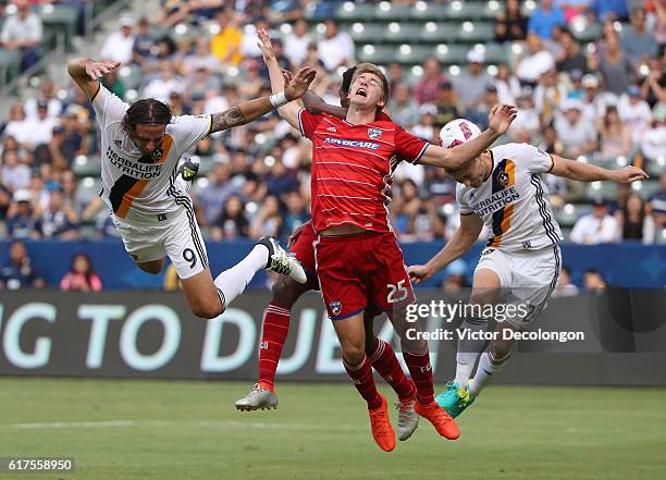 Alan Gordon and Dave Romney of the Los Angeles Galaxy and Walker Zimmerman and Atiba Harris of FC Dallas vie for the cross during their MLS match at...