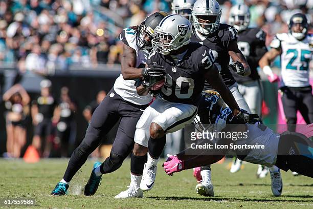 Oakland Raiders Running Back Jalen Richard is wrapped up by Jacksonville Jaguars Safety Jarrod Wilson during the NFL game between the Oakland Raiders...