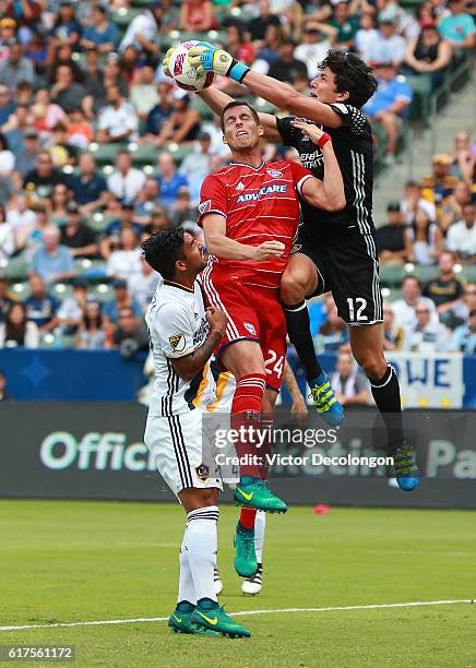 Goalkeeper Brian Rowe of the Los Angeles Galaxy makes a save as Matt Hedges of FC Dallas tries to get a head on the cross while A. J. DeLaGarza of...