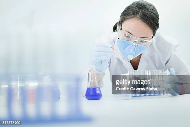 asian woman scientist working with chemical in a laboratory. - prateleira de tubos de ensaio imagens e fotografias de stock