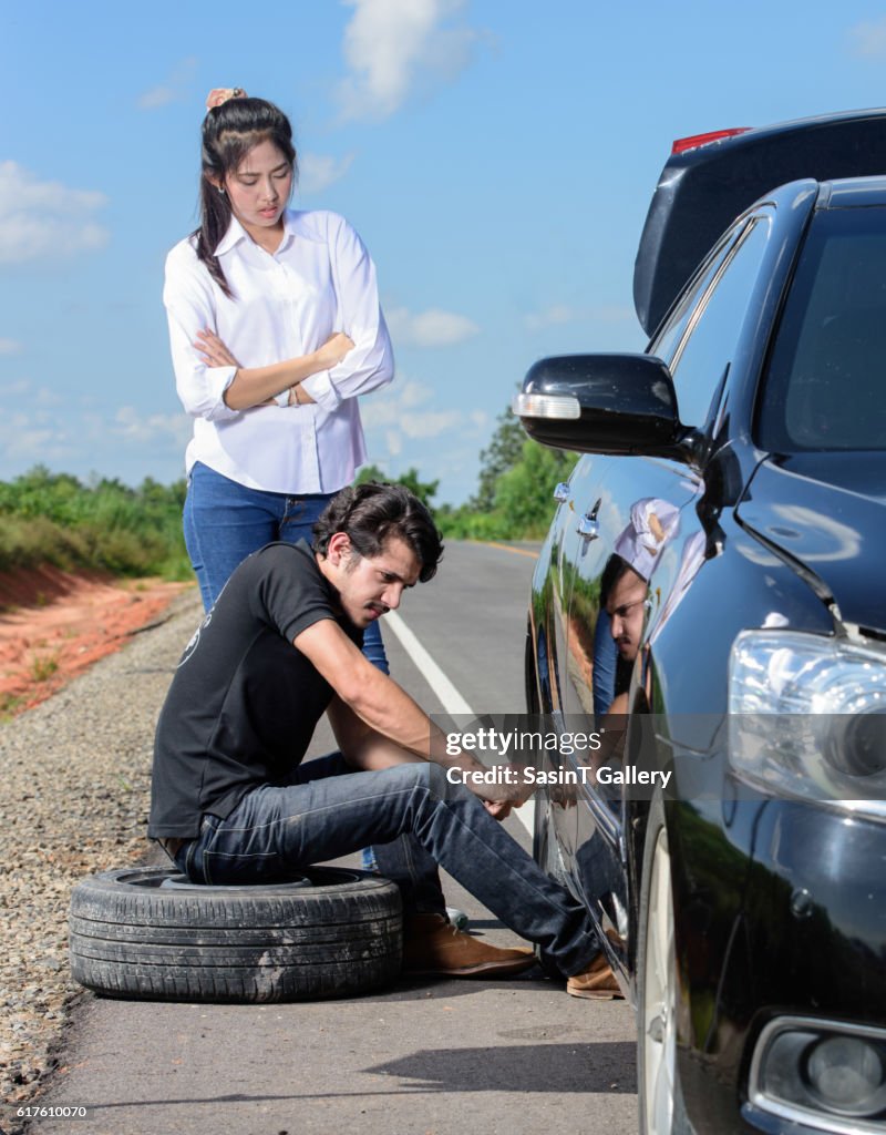 Broken wheel man changing tire