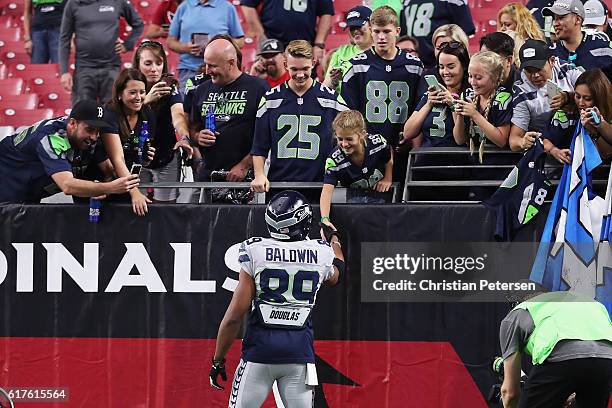 Wide receiver Doug Baldwin of the Seattle Seahawks shakes hands with a fan prior to the NFL game between the Seattle Seahawks and Arizona Cardinals...