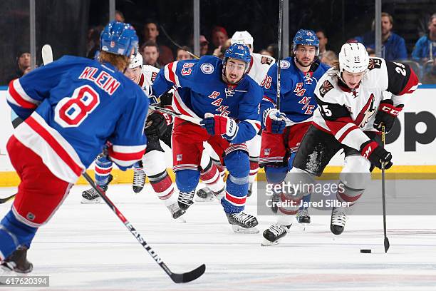 Ryan White of the Arizona Coyotes skates with the puck against Kevin Klein, Mika Zibanejad and Mats Zuccarello of the New York Rangers at Madison...