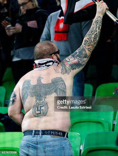 Nazi-symbol tattooed ultra fan of Budapest Honved holds a flag during the Hungarian OTP Bank Liga match between Ferencvarosi TC and Budapest Honved...