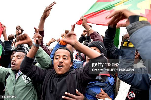 Ethiopian migrants wave the Oromo Liberation Front flag as they celebrate leaving the Calais "Jungle" camp, in Calais, northern France, on October...