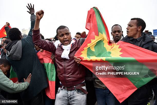 Ethiopian migrants wave the Oromo Liberation Front flag as they celebrate leaving the Calais "Jungle" camp, in Calais, northern France, on October...